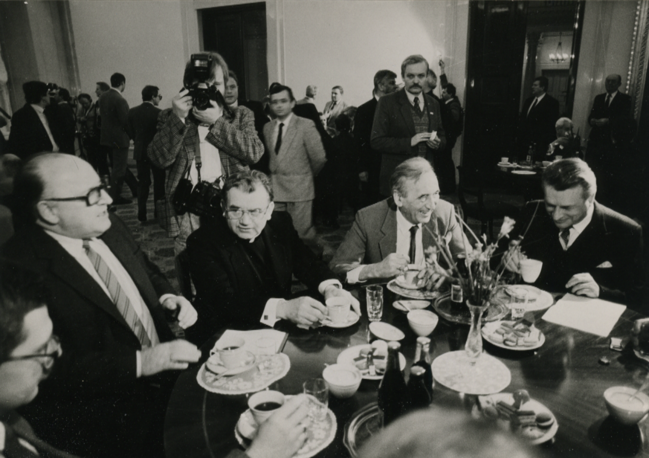 Ks. Alojzy Orszulik w czasie obrad Okrągłego Stołu, po lewej Stanisław Ciosek, po prawej Tadeusz Mazowiecki i gen. Czesław Kiszczak; źródło: IPN