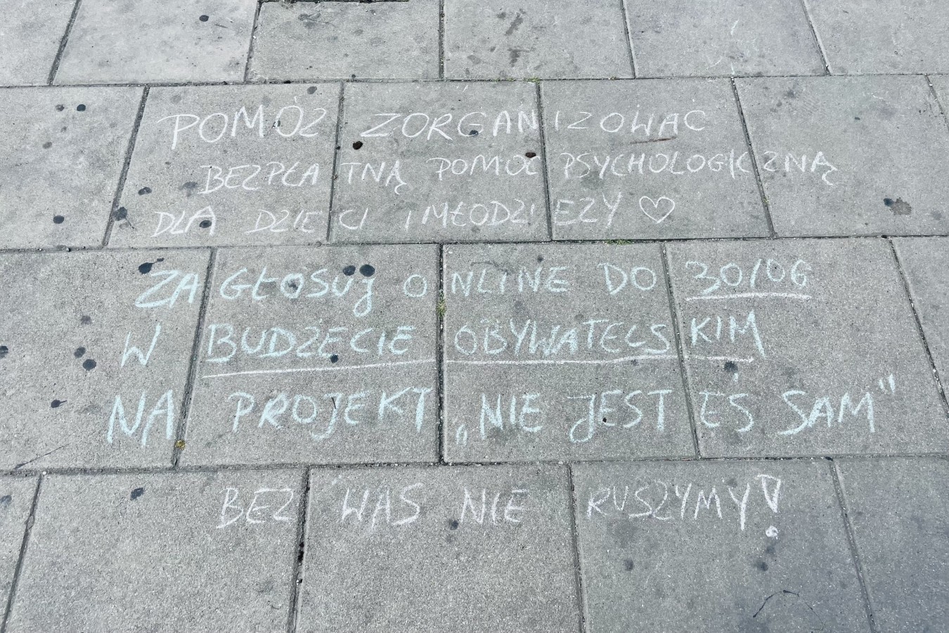 Napis kredą na chodniku między Pałacem Kultury i Nauki a dworcem Warszawa Centralna, czerwiec 2023