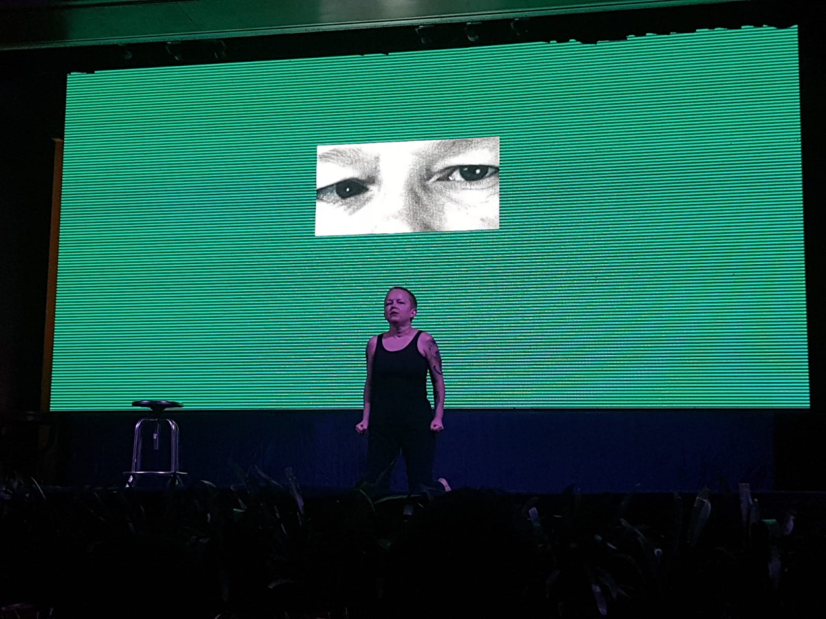 Katarzyna Żeglicka, Rezonans kontrastu Katarzyna Żeglicka, Rezonans kontrastu; fot. Agnieszka Król. Na środku czarnej sceny stoi performerka – Katarzyna Żeglicka – ma bardzo krótkie, ciemne włosy, jest ubrana w czarny podkoszulek i czarne spodnie; opuszczone wzdłuż ciała ręce wieńczą zaciśnięte pięści. Żeglicka stoi na tle zielonego ekranu; na jego środku wyświetlony jest czarno biały, prostokątny kadr z pokazanymi w dużym zbliżeniu i powiększeniu oczami artystki. Po lewej stronie stoi obrotowy taboret medyczny.